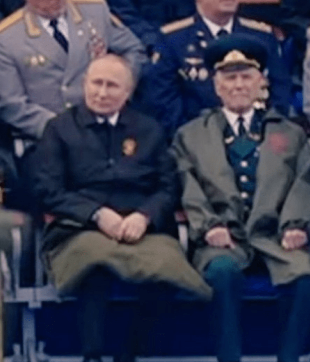 Putin sits with a heavy blanket across his knees in the 9C temperature in Moscow