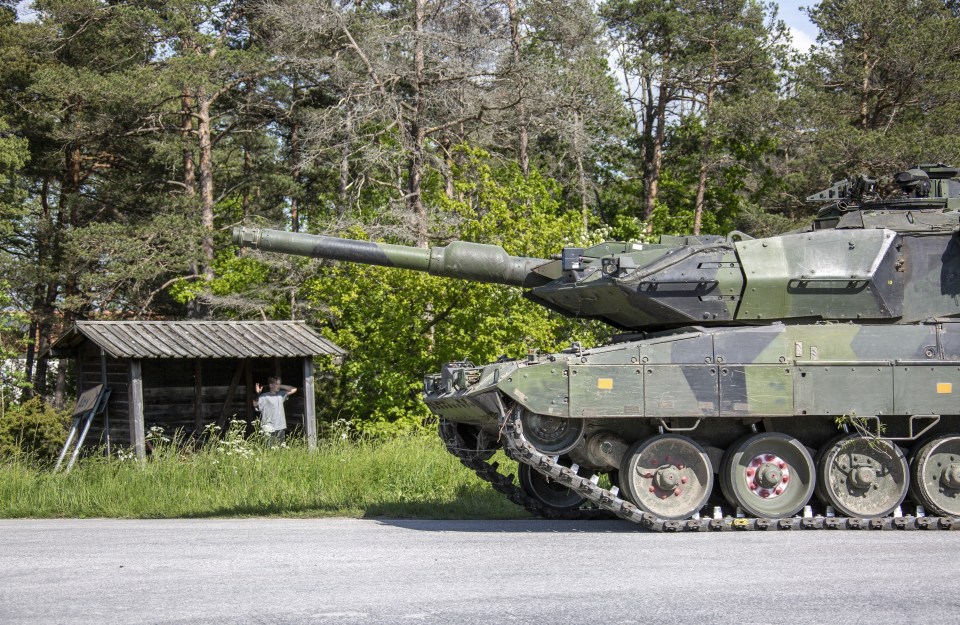 A military tank column moves on a road strip during an invasion rehearsal