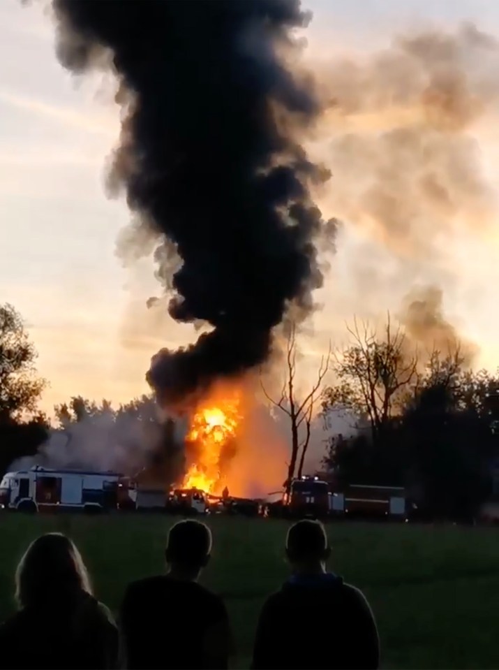 A crowd of onlookers watched the aftermath of the fiery crash