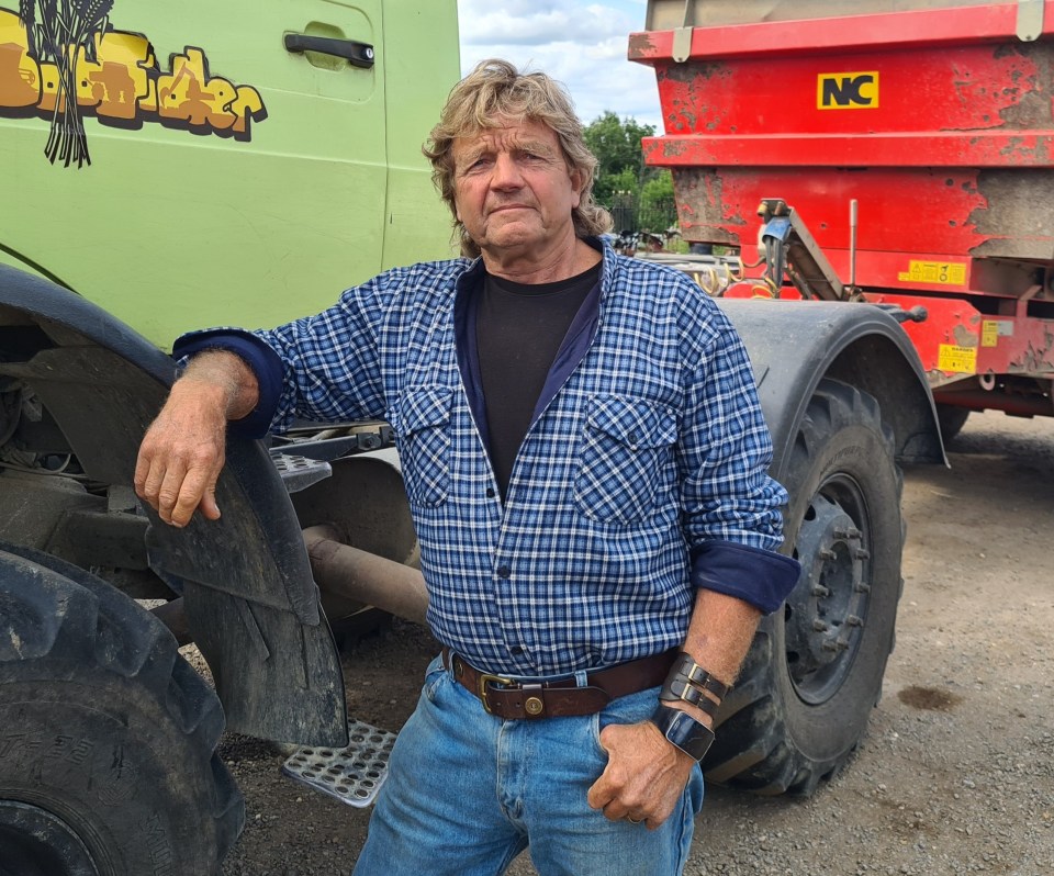 a man in a plaid shirt leans on the side of a truck that says nc