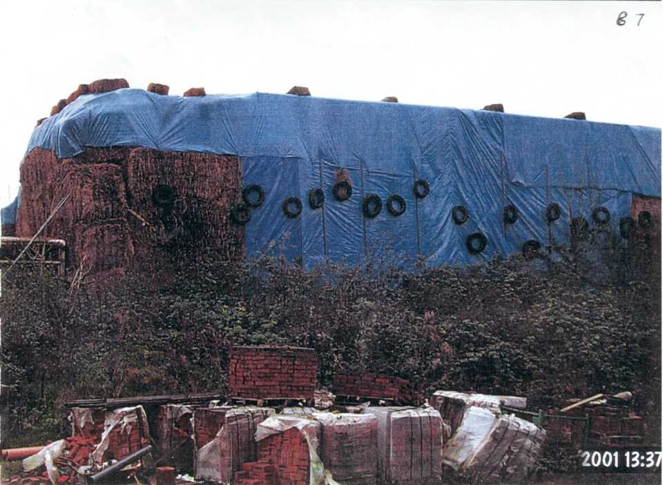 a blue tarp is covering a pile of bricks and tires