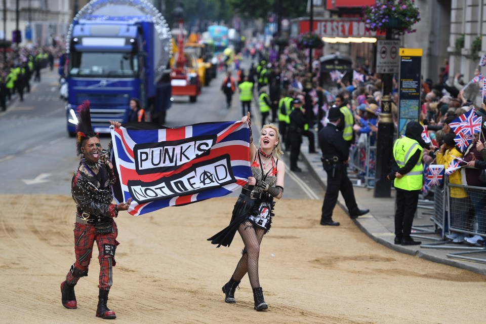 1970s - pair are dressed in iconic punk clothes and carrying a Union Jack as part of the Jubilee pageant’s tribute to the '70s