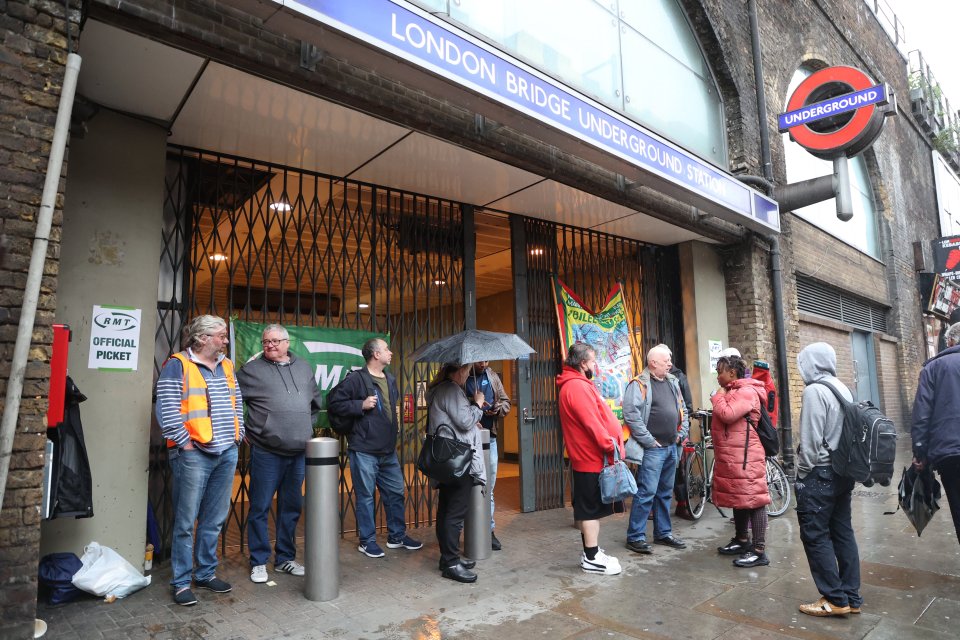 Londoners shelter in a closed underground station out of the rain