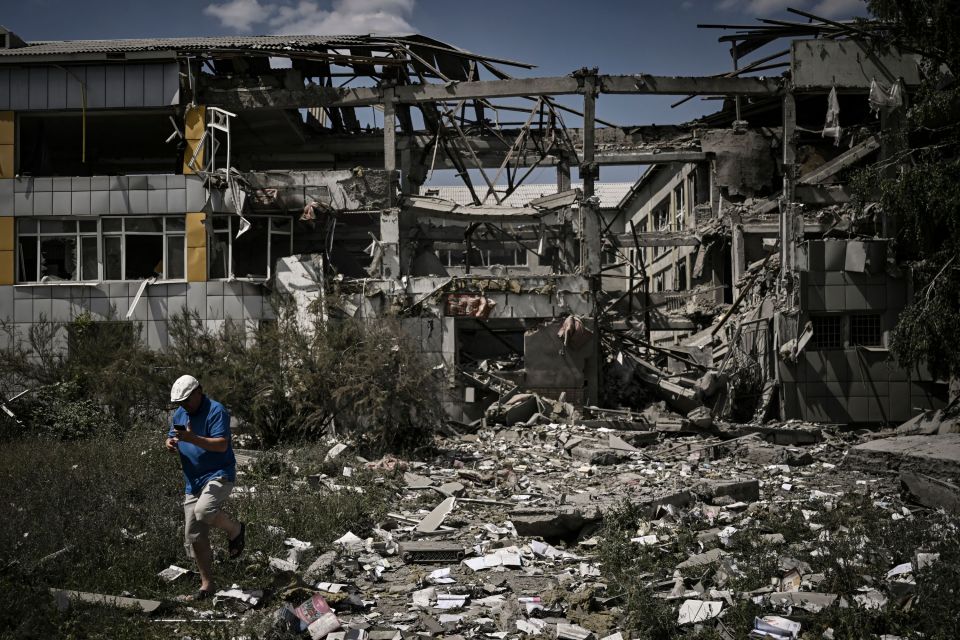 A local resident walks in front of a destroyed school after a strike in the city of Bakhmut, eastern Ukrainian region of Donbas on June 8, 2022. (Photo by ARIS MESSINIS / AFP) (Photo by ARIS MESSINIS/AFP via Getty Images)