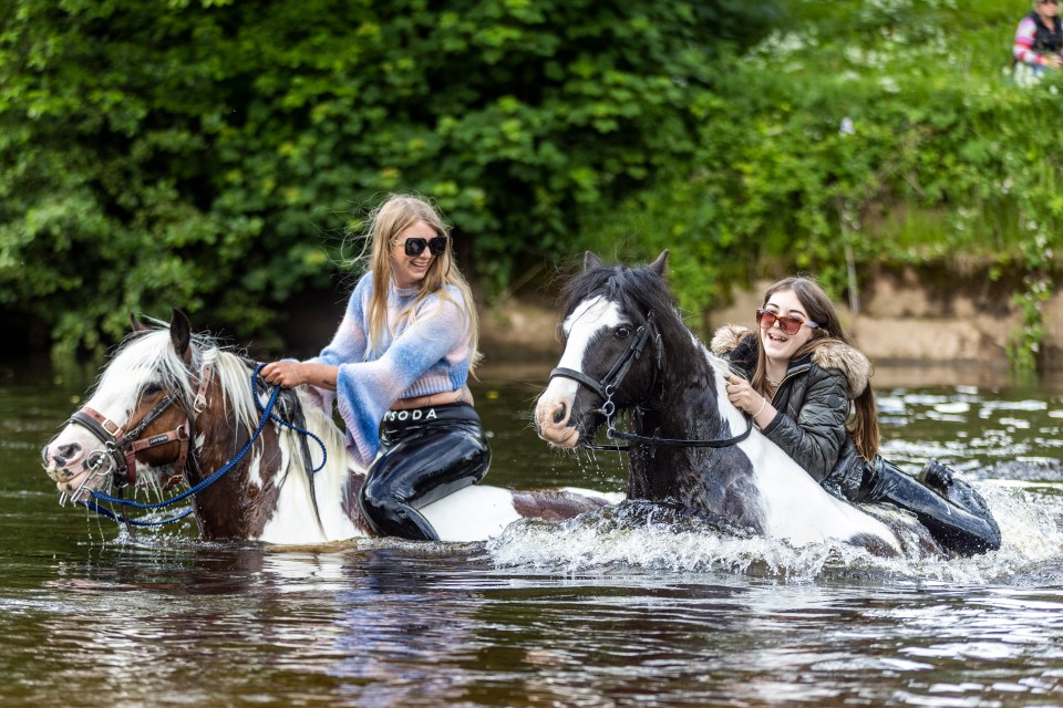 Two women have some fun as they take their horses for a dip in the River Eden