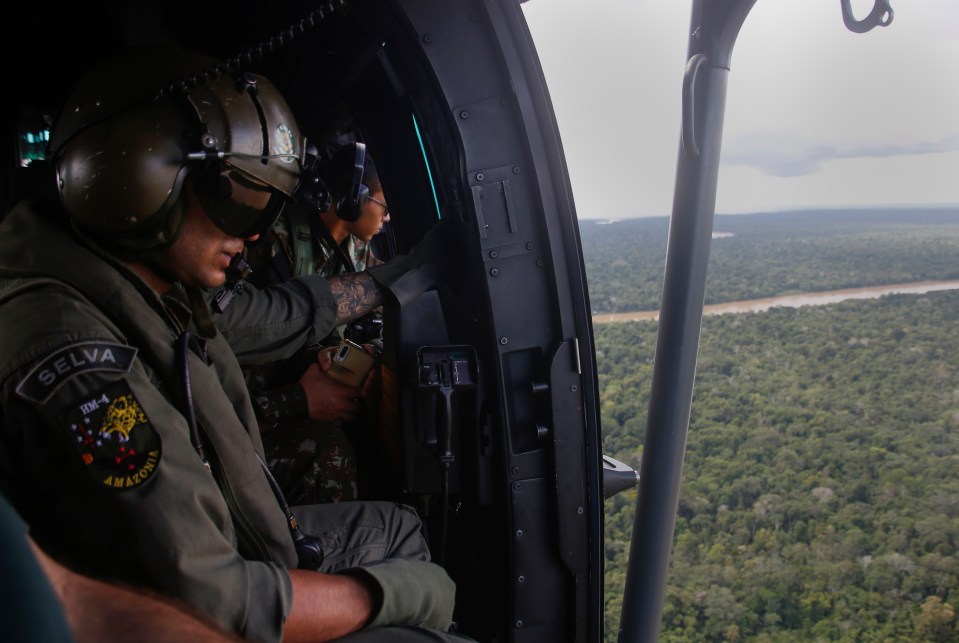 Soldiers search for using helicopters as they fly over the Amazon