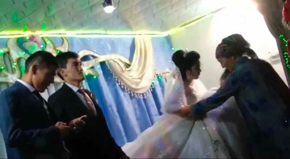 The bride is ushered away by two women following the disgusting punch