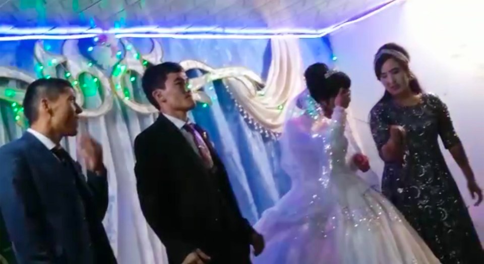 The bride is seen holding her head in agony after the vicious blow