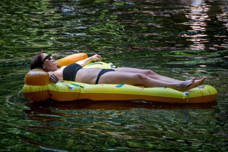 A woman relaxed in the heat at the canal in Hackney, East London