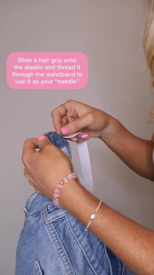 She threads the elastic through the jeans