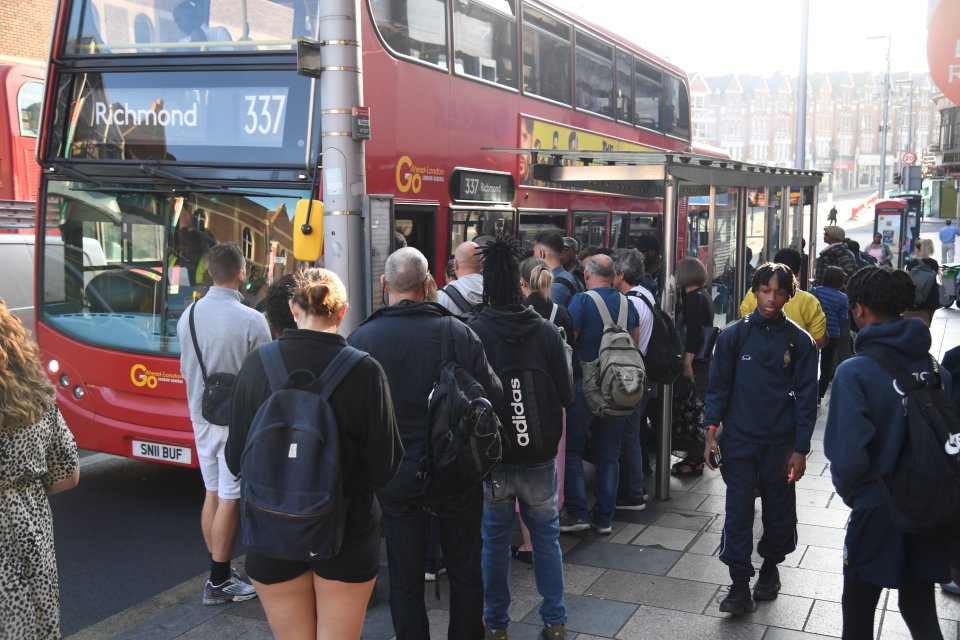 Brits queue for the bus outside Clapham Junction station as another day of rail misery kicks off