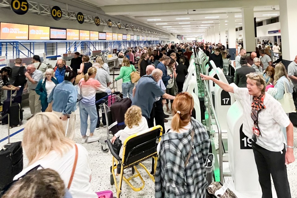 Passengers queue for check-in at Manchester Airport