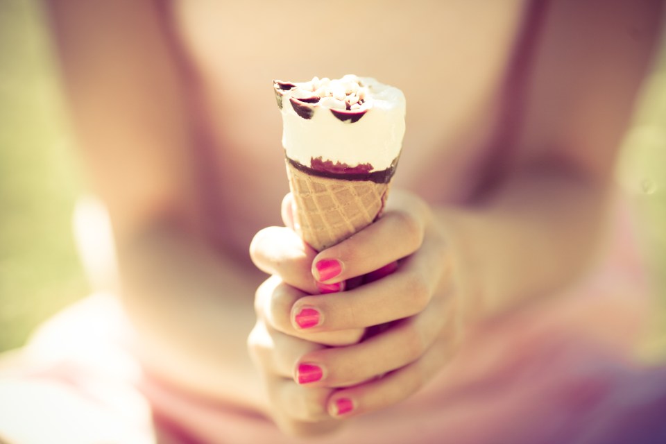 Girl holding cornetto Ice-cream in hands.