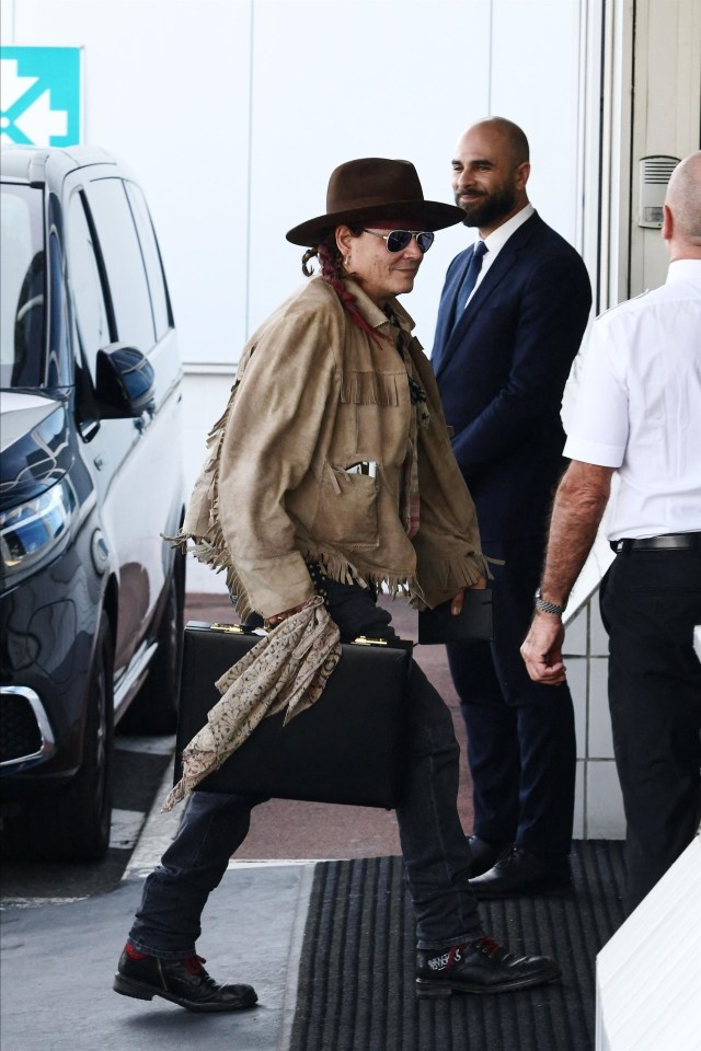 Johnny Depp was pictured at Paris airport wearing braided hair and a fringed jacket