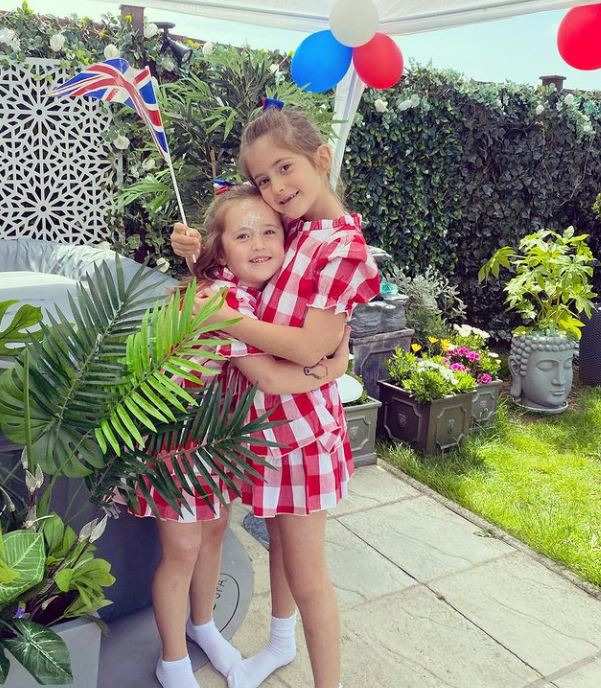 Mia and Ella in their garden party with flags