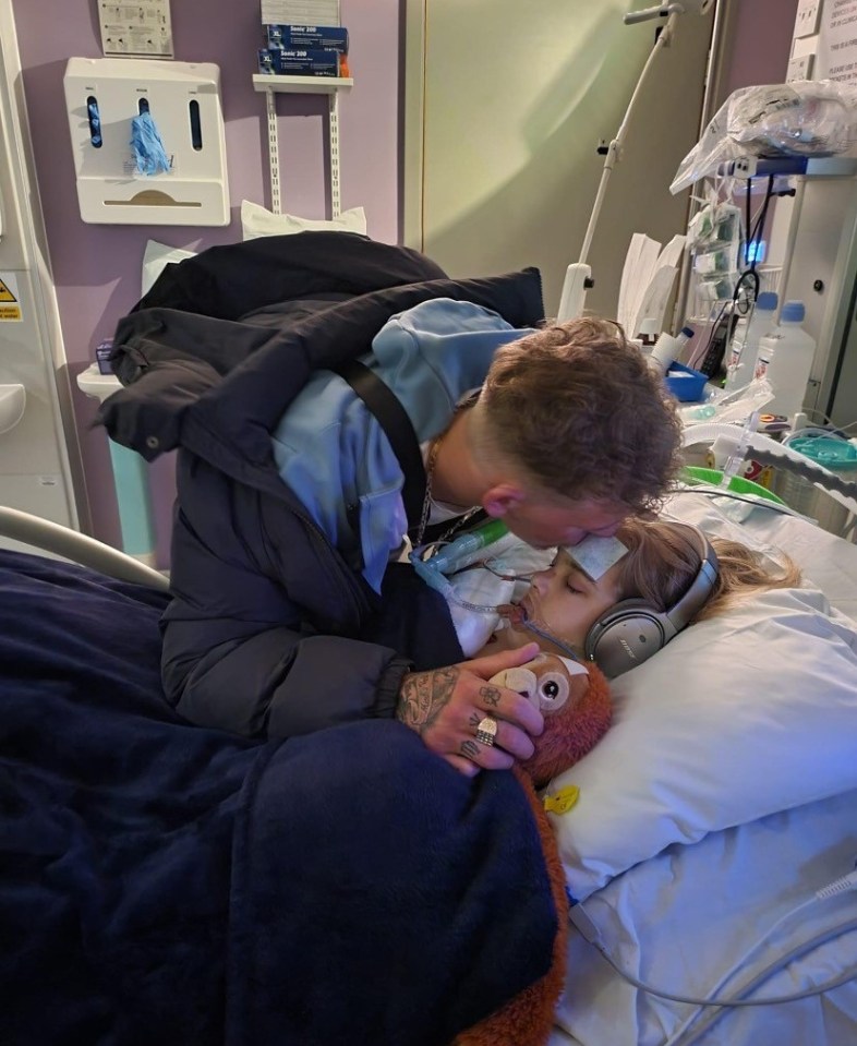 Archie's brother Tom Summers is seen kissing the youngster on the head in hospital