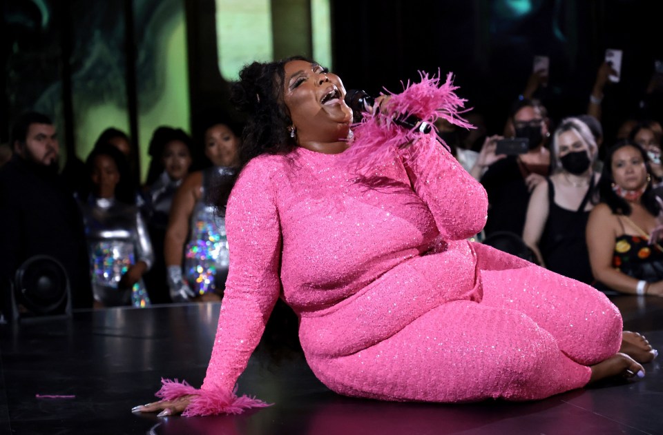 Lizzo wore a pink sequined jumpsuit with feathered sleeves on stage