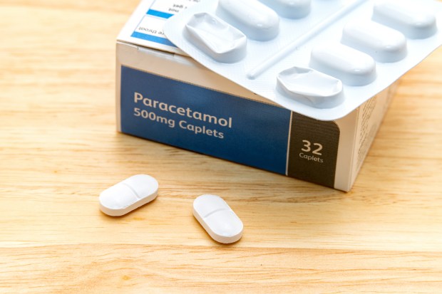 a box of paracetamol 500mg caplets sits on a wooden table