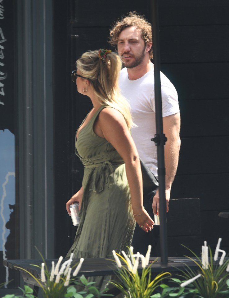 Emily looked chic in black shades and a green wrap dress while Seann stayed cool in a plain white t-shirt