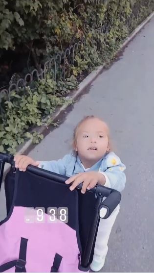 Her daughter pushes the pram alongside her