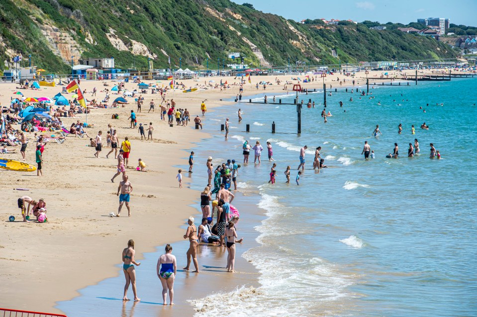 People soak up the sun and enjoy the heat on the beach in Bournemouth, Dorset