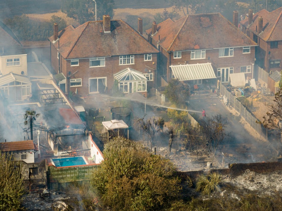 A firefighter using a hose to tacke the blaze