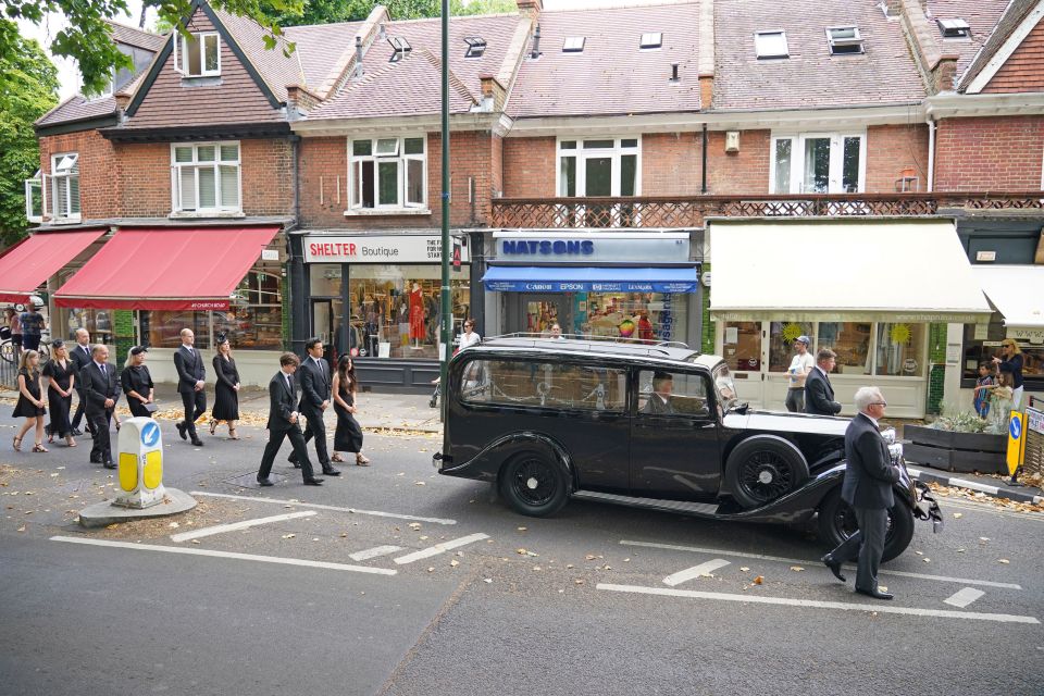 Son Hugo, husband Sebastien Bowen, and daughter Eloise, walk with family behind the hearse as it arrives for the funeral service