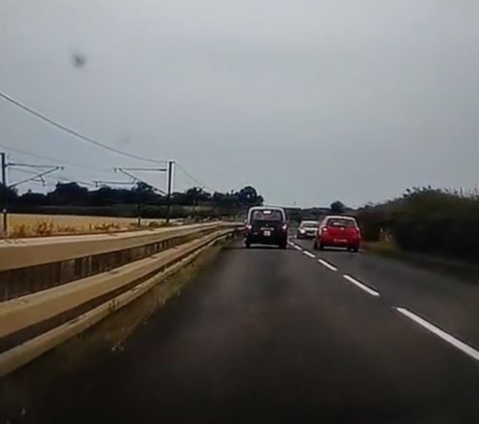 The driver of the red Toyota Yaris attempts to overtake the black cab, only to get caught out by the blind corner