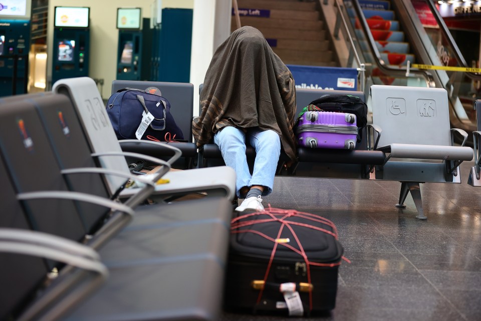 A passenger waits at a deserted Manchester Piccadilly Station this morning