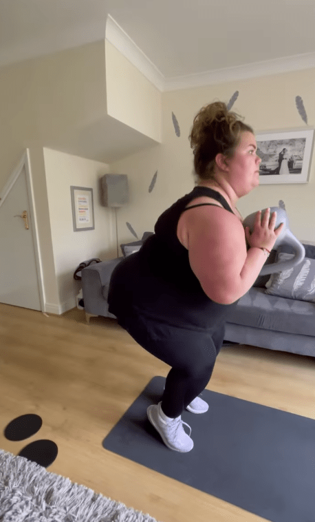 Amy did squats with a kettle bell in her living room