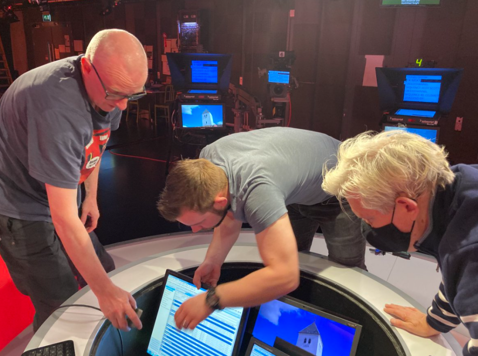 Studio crew scramble to fix a collapsed laptop stand as a pre-recorded travel segment aired