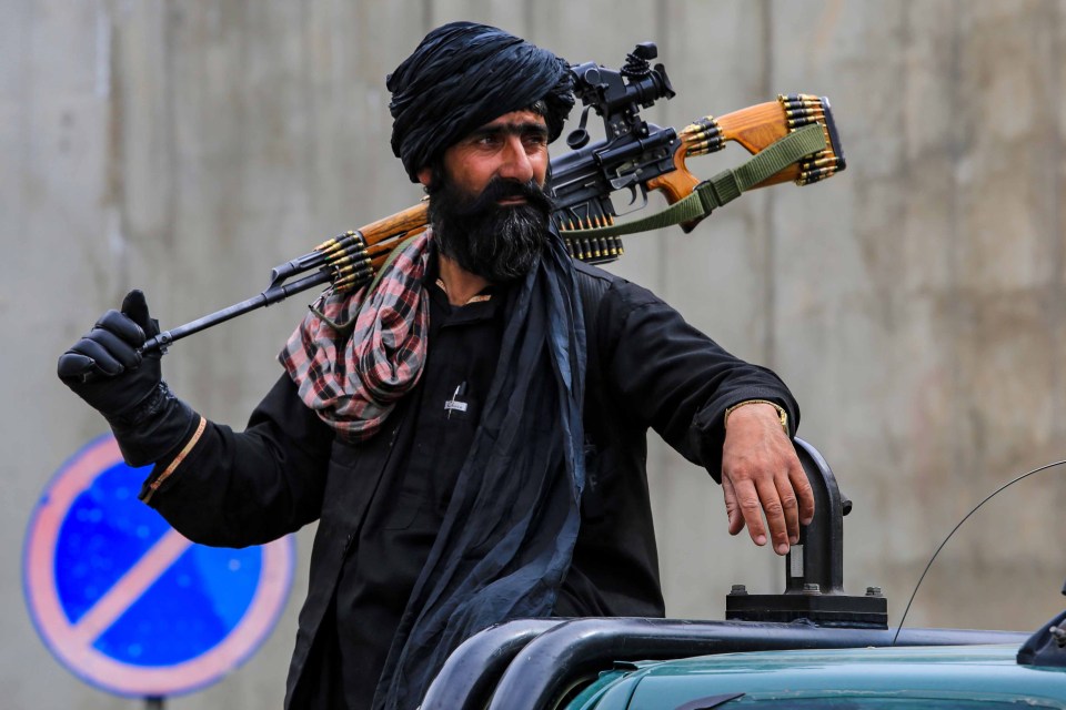 Taliban security stand guard in the neighbourhood where a US drone strike killed the Al-Qaeda leader