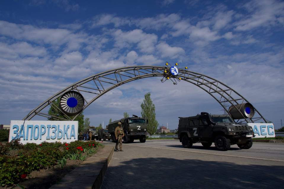 Russian military vehicles drive through the gates of the ZNPP