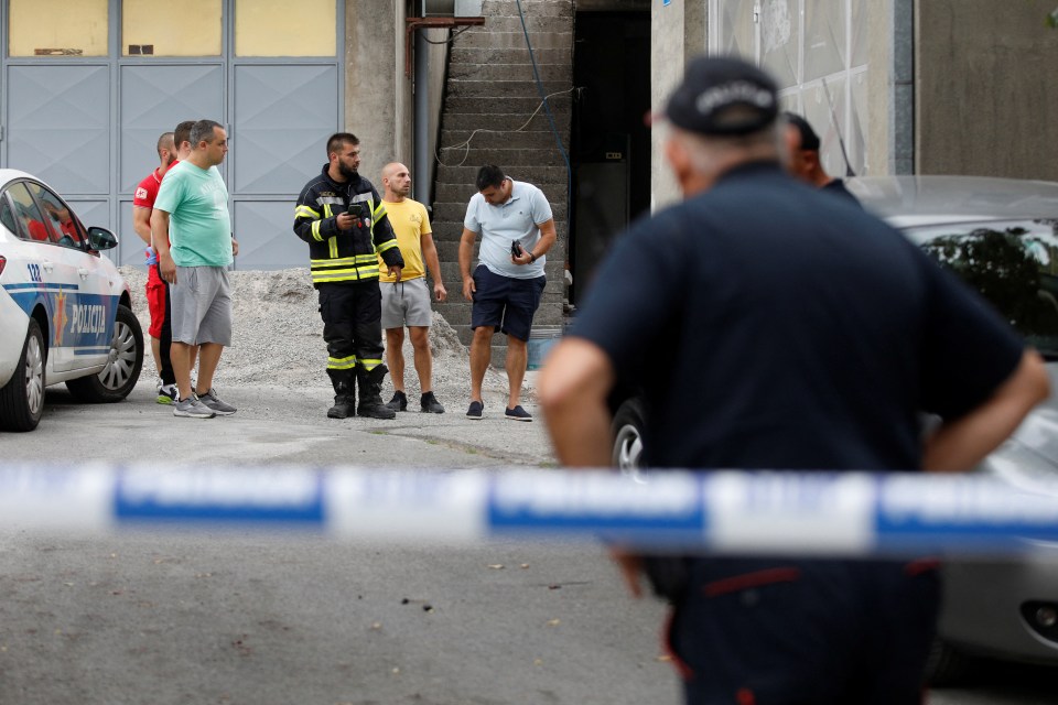 Rescue personnel talks to citizens at the crime scene of a mass shooting