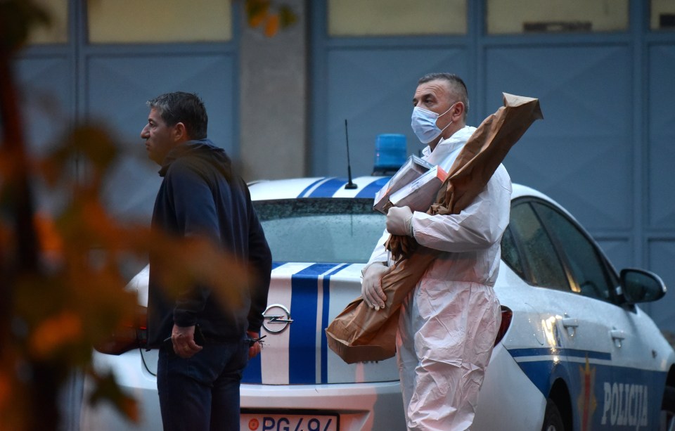 A crime scene investigator carries a rifle as evidence believed to belong to the perpetrator