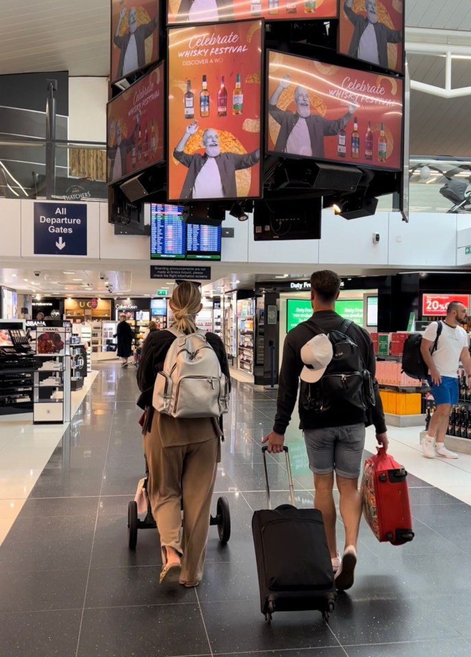 The family pushing the buggy through the airport in June