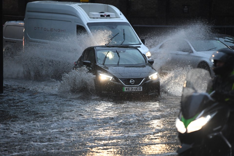 Heavy rainfall is drenching Britain this morning, with commuters in London battling flooded roads