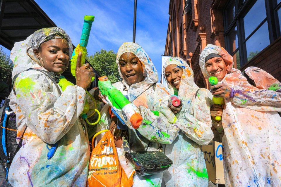 Revellers have fun, covered in coloured powder, flower and paint, at the early morning J’ouvert celebration, a traditional part of Notting Hill Carnival