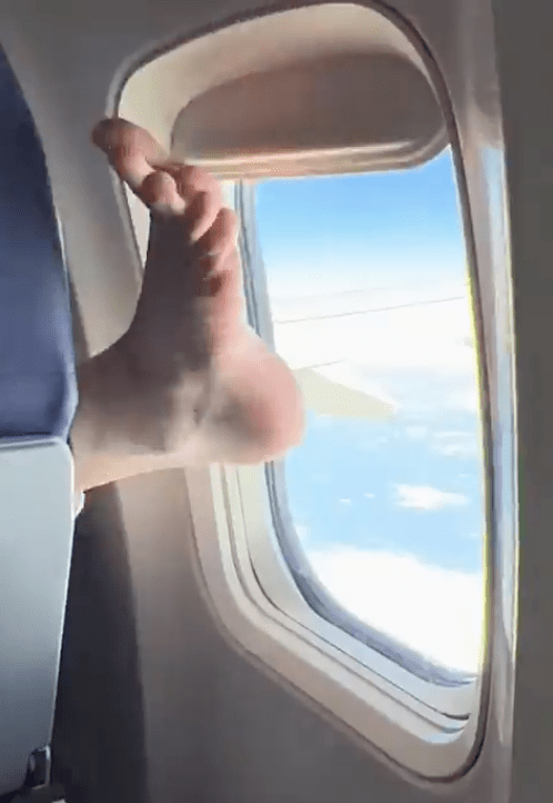 A woman was horrified after a passenger used their bare foot to close the window shade