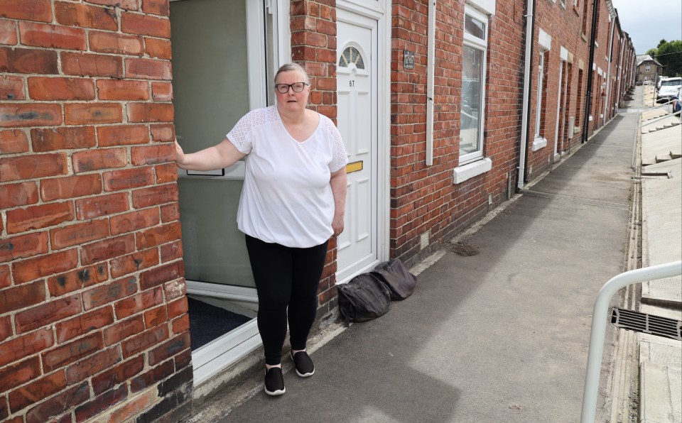 Lynn stands outside her home