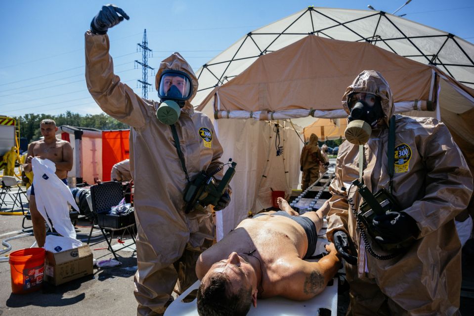 Ukraine ministry workers carry geiger counters and wear gas masks