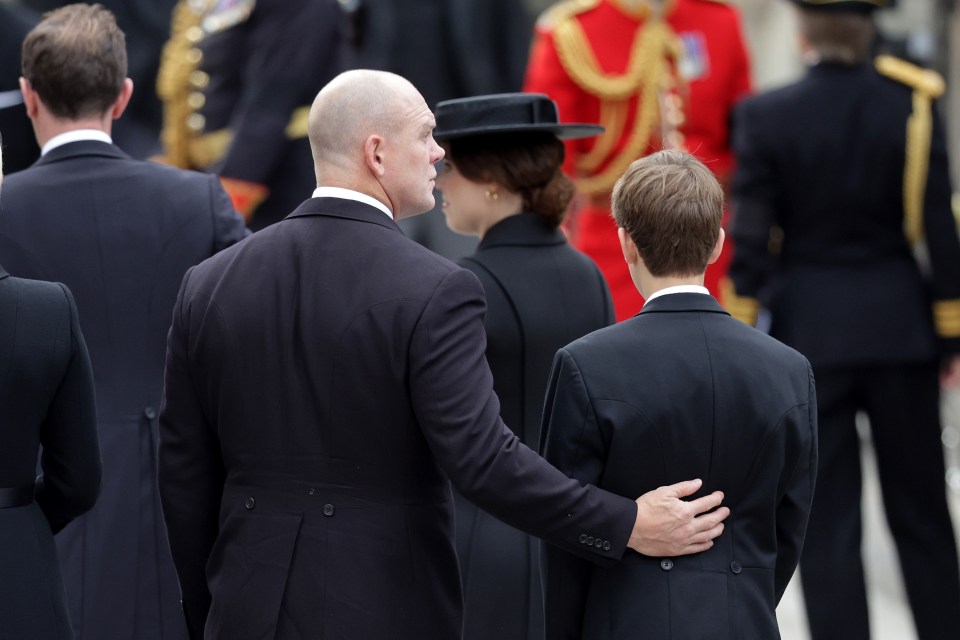 Mike Tindall puts a comforting arm around James, Viscount Severn as they enter Westminster Abbey