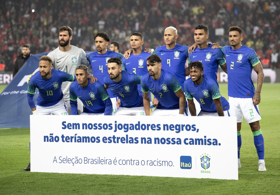 Brazil's team pose with an anti-racism banner before the game