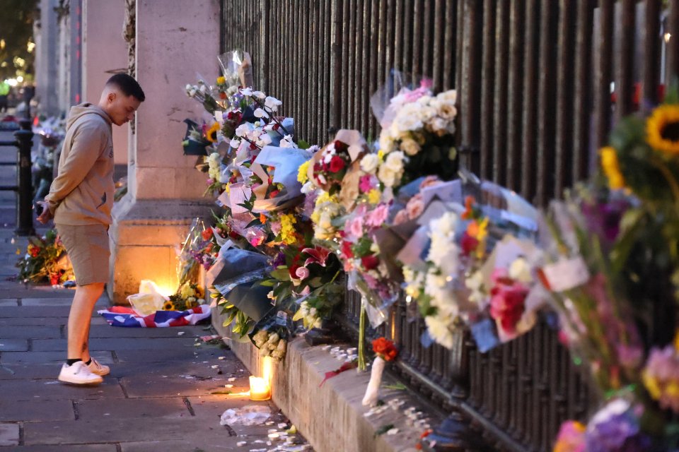 Flowers lined up along the railings outside Buckingham Palace