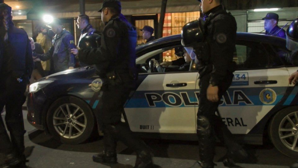 Police escort the suspect from the scene in Buenos Aires last night