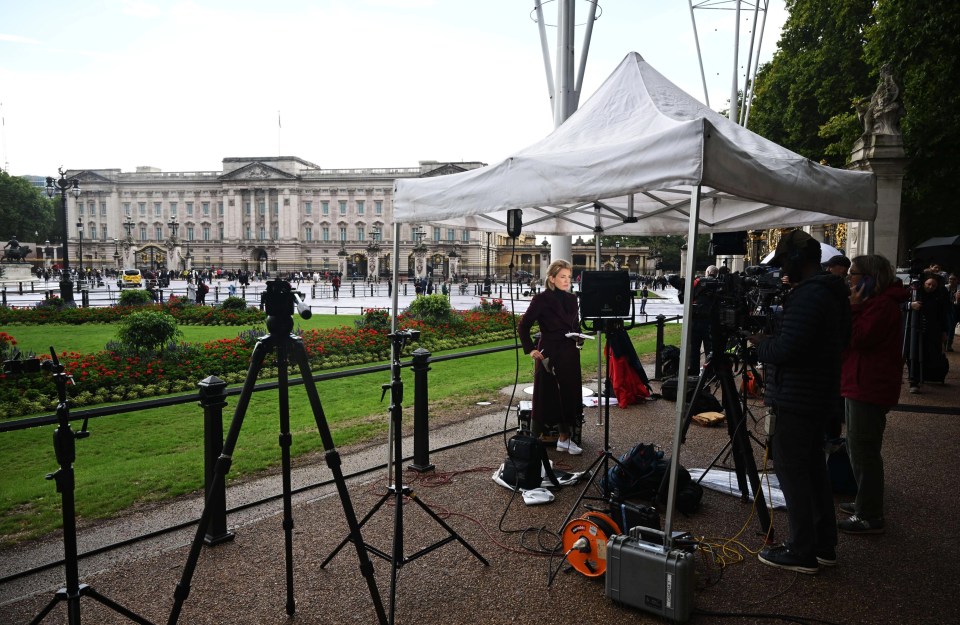 Television crews and media report from outside Buckingham Palace