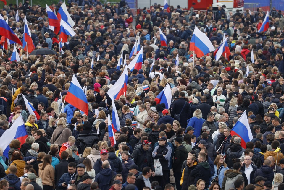 People wave Russian flags during a rally in Moscow’s Red Square