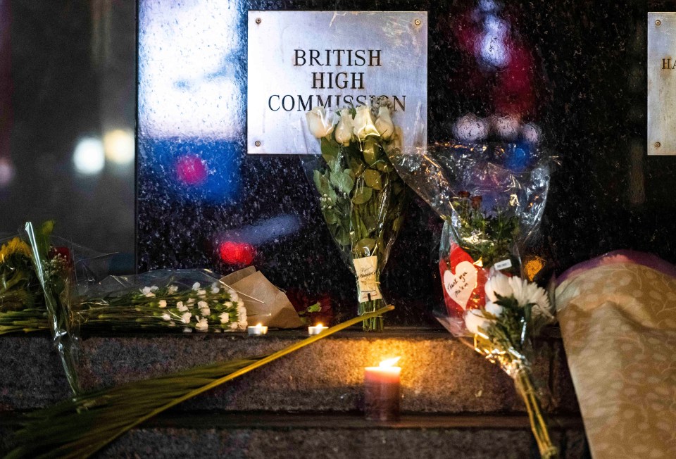 Flowers and candles lay on the steps of the British High Commission in Ottawa, Canada