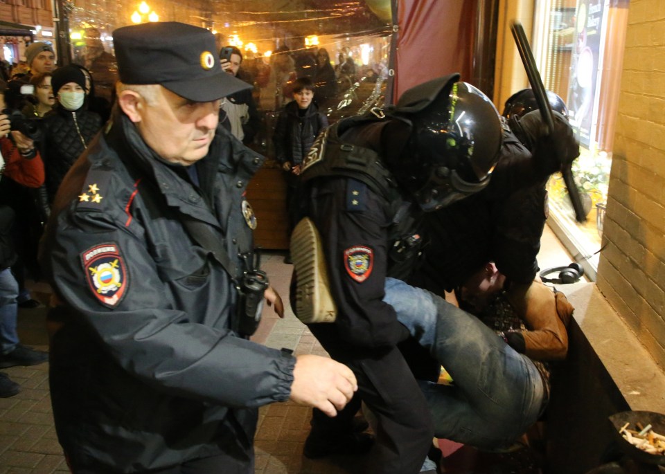 A riot policeman hitting a demonstrator