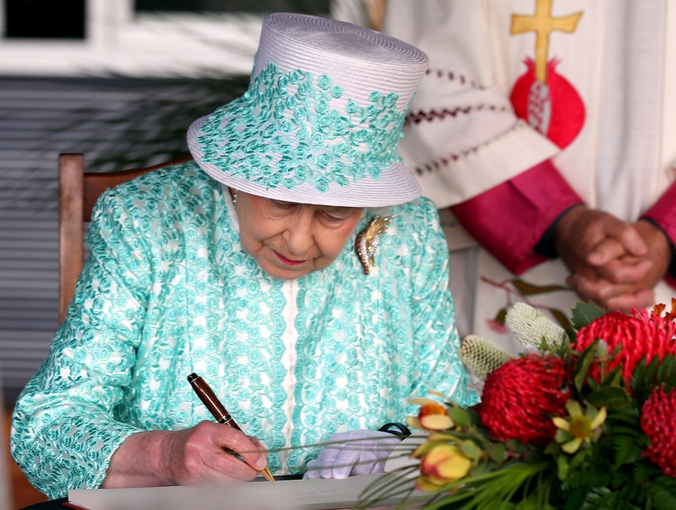 The Queen writing a note while on a visit to Australia